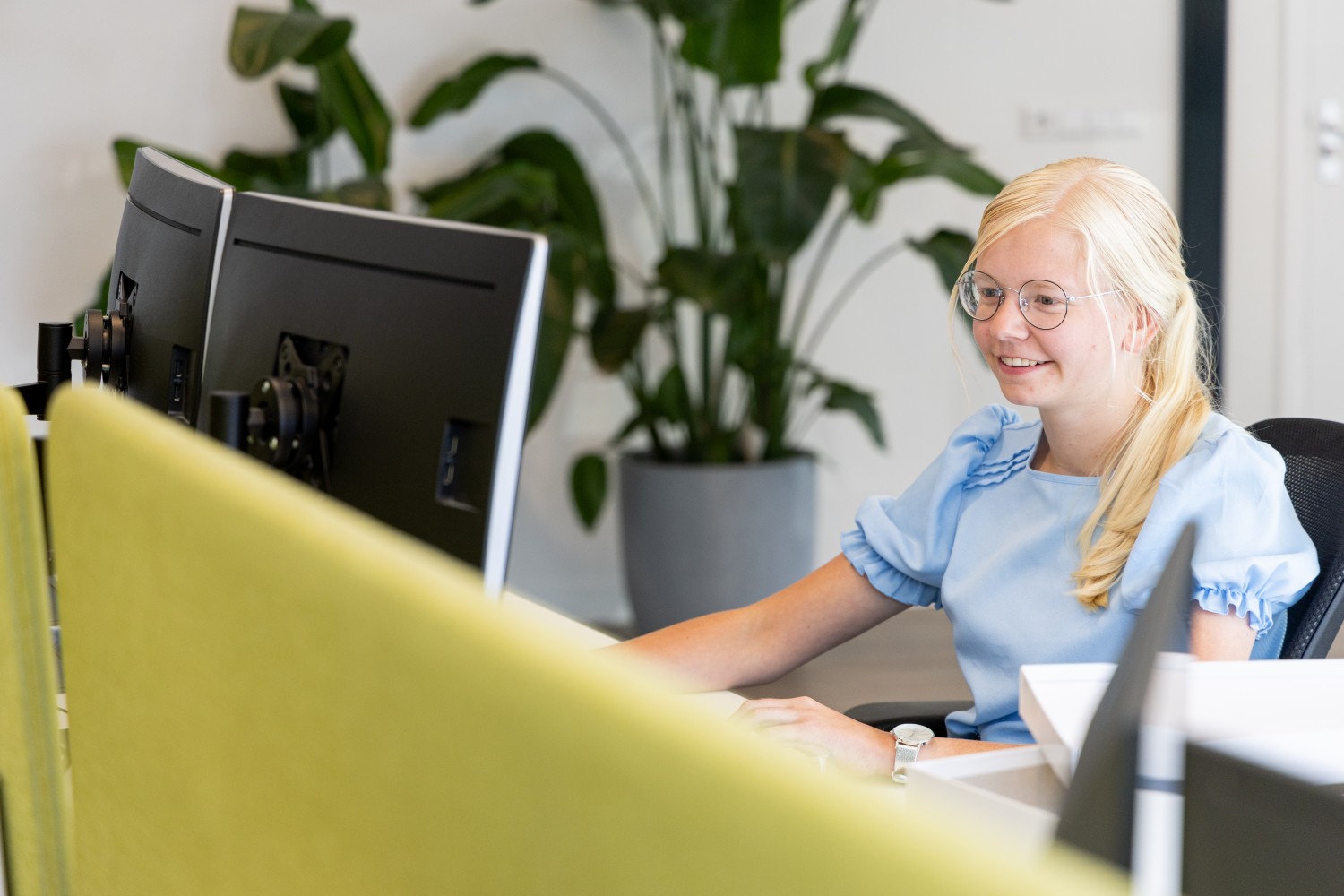 Greengiving employee working at a computer in the office