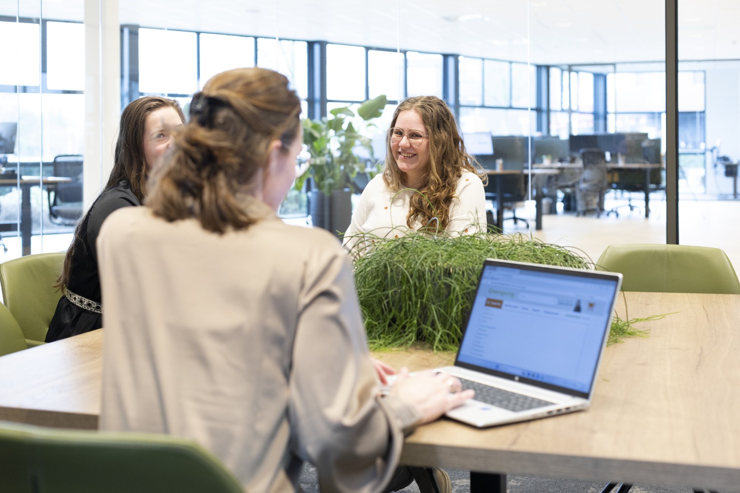 Greengiving team discussing around a table with a laptop